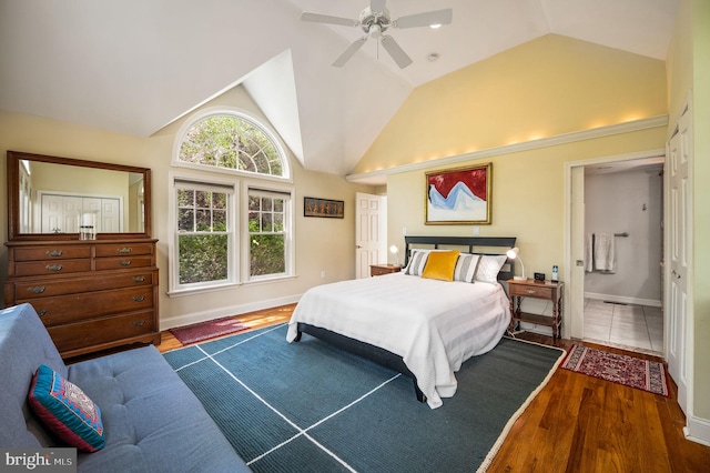 bedroom featuring wood finished floors, a ceiling fan, vaulted ceiling, and baseboards