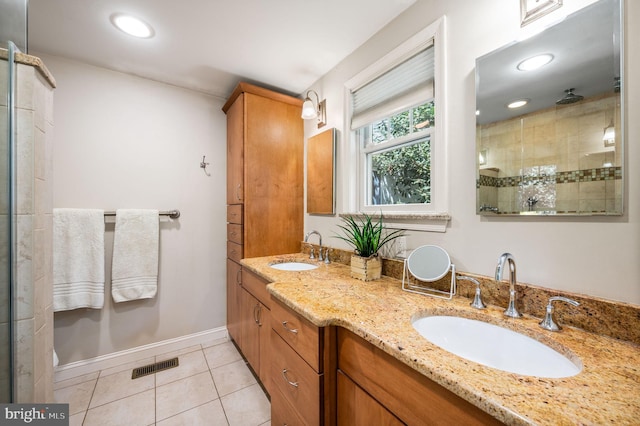 bathroom featuring tile patterned floors, visible vents, tiled shower, and a sink