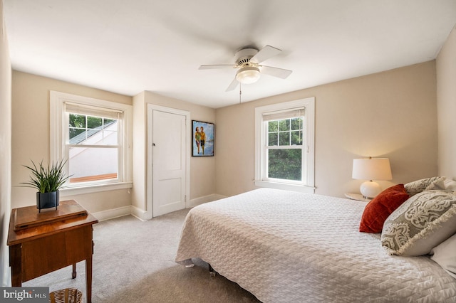 carpeted bedroom with baseboards, ceiling fan, and multiple windows