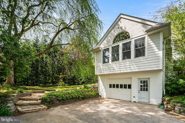 view of property exterior with stucco siding, aphalt driveway, and a garage