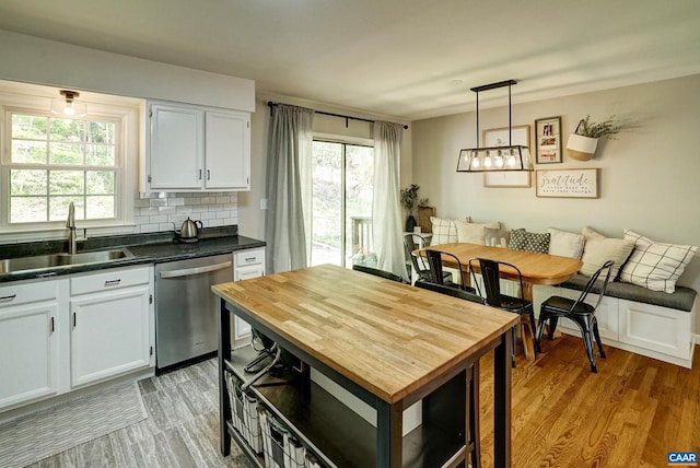209 Old Lynchburg Rd, Charlottesville, VA 22903 - kitchen with dark countertops, tasteful backsplash, stainless steel dishwasher, a sink, and light wood finished floors