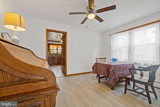 dining area featuring a ceiling fan, baseboards, and light wood-style floors
