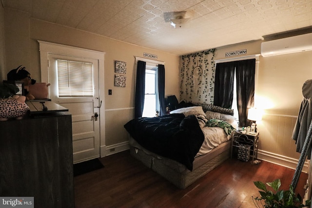 bedroom featuring an ornate ceiling, wood finished floors, and a wall mounted air conditioner