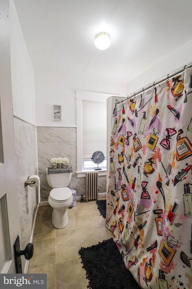 full bathroom with tile walls, curtained shower, toilet, a wainscoted wall, and radiator heating unit