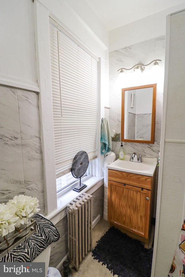 half bathroom featuring radiator heating unit and vanity
