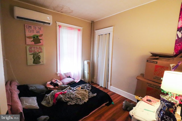 bedroom featuring a wall unit AC, baseboards, radiator, ornamental molding, and wood finished floors