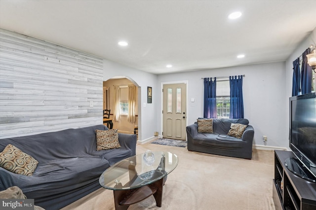 living room featuring recessed lighting, arched walkways, and baseboards