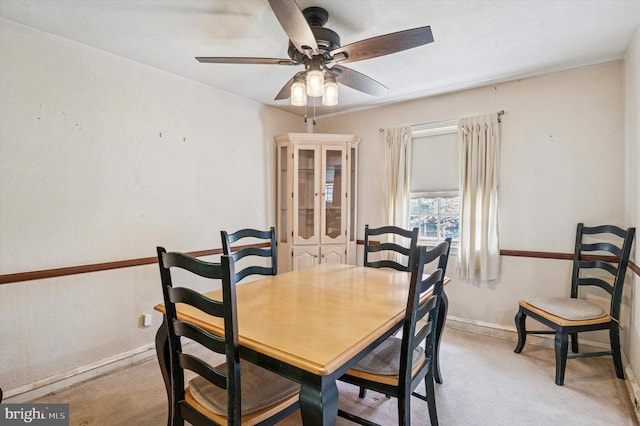 dining space with a ceiling fan and baseboards