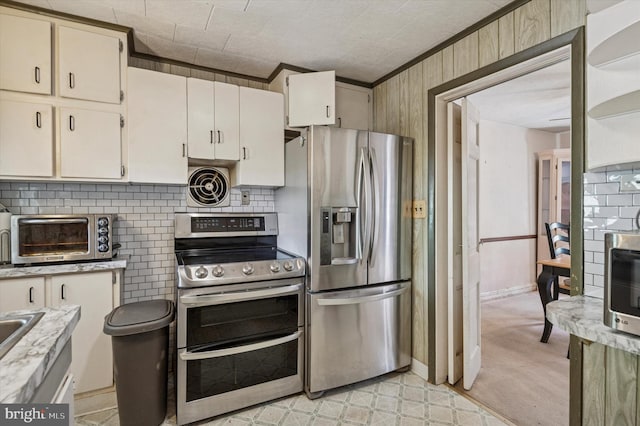 kitchen with a toaster, appliances with stainless steel finishes, light countertops, visible vents, and crown molding