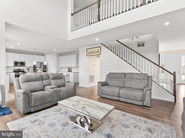 1022 Fawn Haven Walk, Dover, DE 19901 - living room with visible vents, stairs, a towering ceiling, wood finished floors, and recessed lighting