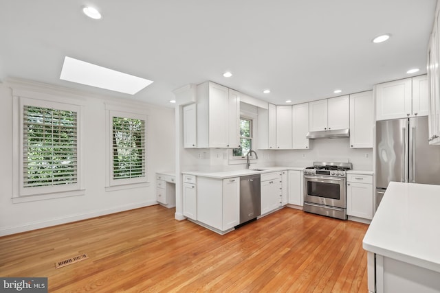 9373 Robnel Pl, Vienna, VA 22182 - kitchen with appliances with stainless steel finishes, light countertops, under cabinet range hood, a skylight, and visible vents