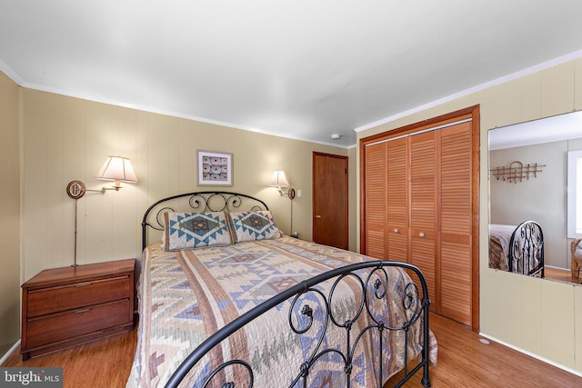 bedroom featuring a closet, crown molding, and wood finished floors