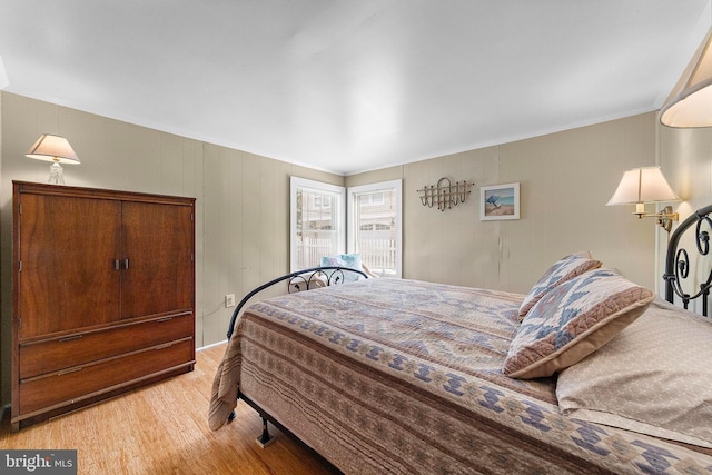 bedroom featuring ornamental molding and light wood-type flooring