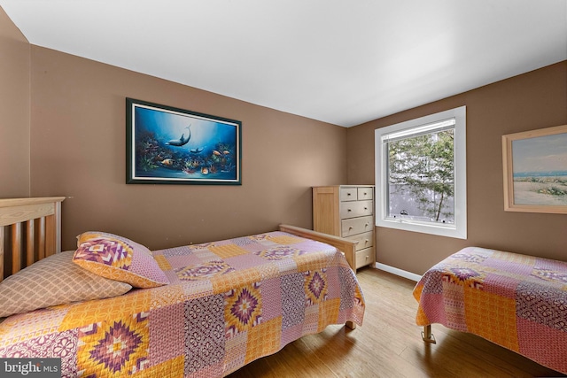 bedroom featuring baseboards and wood finished floors