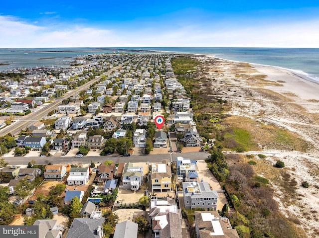 drone / aerial view featuring a beach view, a water view, and a residential view