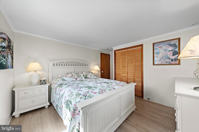 bedroom with crown molding, light wood finished floors, and a closet