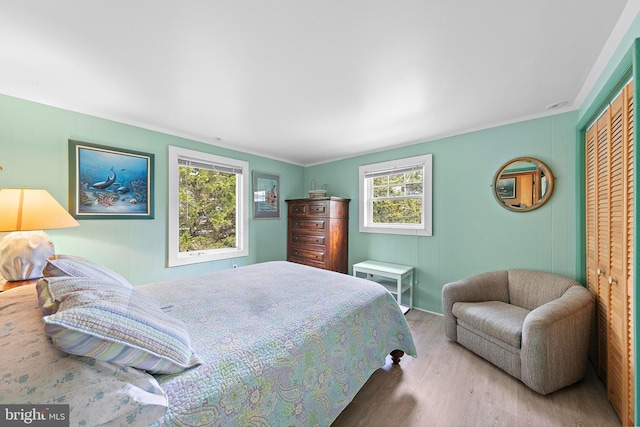 bedroom featuring crown molding, a closet, and wood finished floors