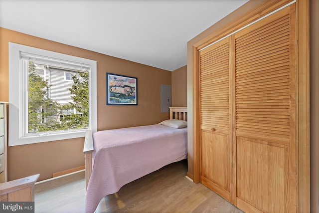 bedroom with baseboards, a closet, and light wood-style flooring