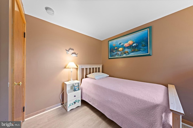 bedroom with light wood-style floors and baseboards