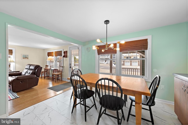 dining room featuring baseboards, marble finish floor, and a chandelier