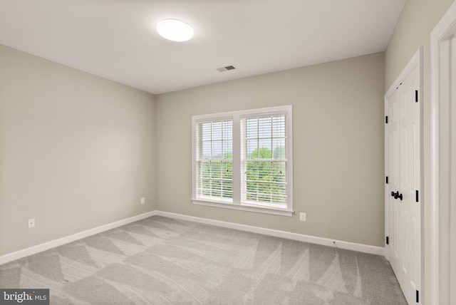 carpeted spare room featuring baseboards