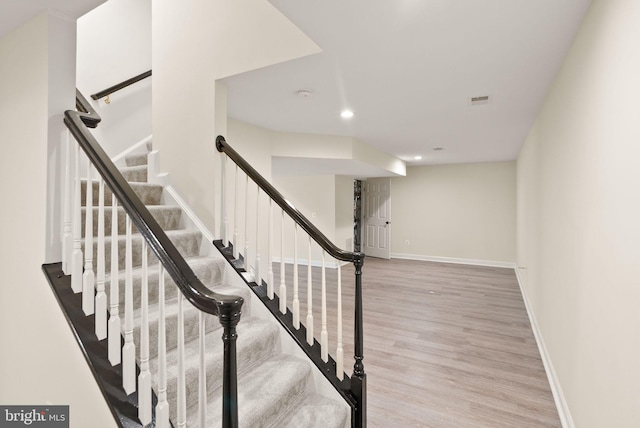stairway with recessed lighting, wood finished floors, and baseboards