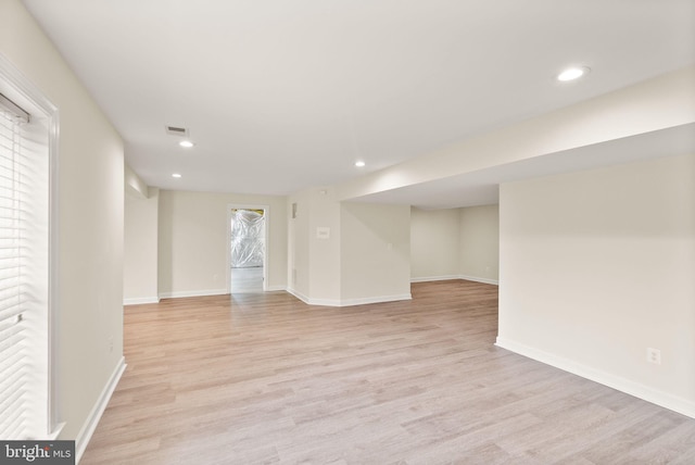 below grade area with light wood-style floors, recessed lighting, and baseboards