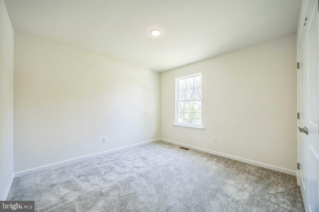 unfurnished room featuring visible vents, carpet flooring, and baseboards