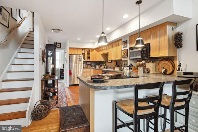 400 S 2nd St Unit 408B, Philadelphia, PA 19147 - kitchen with freestanding refrigerator, pendant lighting, a peninsula, a kitchen breakfast bar, and tasteful backsplash
