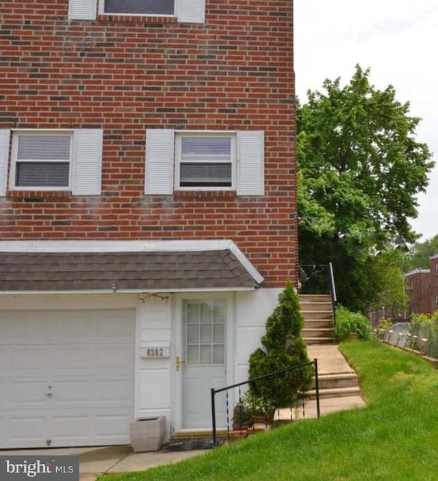 exterior space with a lawn, brick siding, and a garage