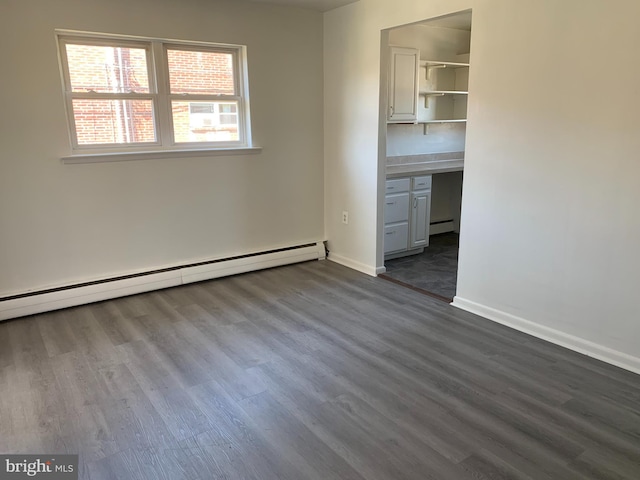 interior space with baseboards, a baseboard radiator, and dark wood-type flooring