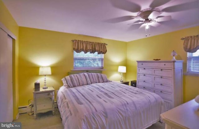 bedroom with a baseboard heating unit and a ceiling fan
