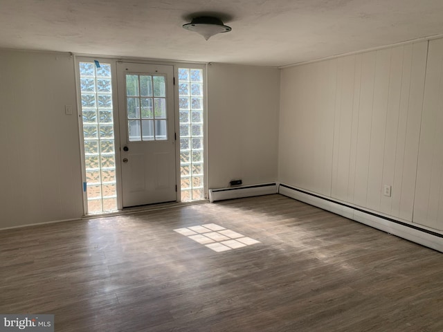 interior space with baseboards, wood finished floors, and a baseboard radiator