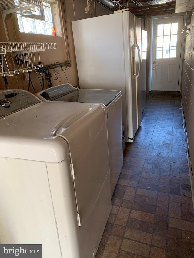 laundry area featuring washing machine and dryer, brick patterned floor, and laundry area