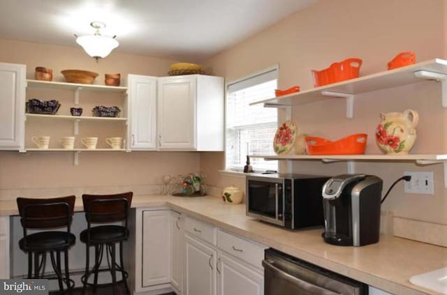 kitchen featuring appliances with stainless steel finishes, open shelves, and white cabinets