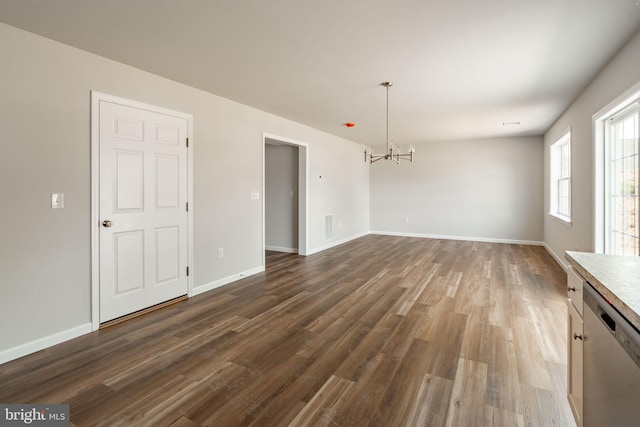 unfurnished dining area with baseboards, visible vents, an inviting chandelier, and dark wood-type flooring