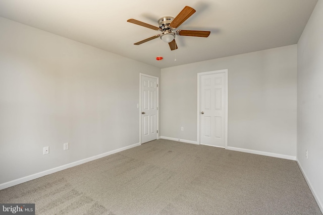 spare room featuring ceiling fan, carpet, and baseboards
