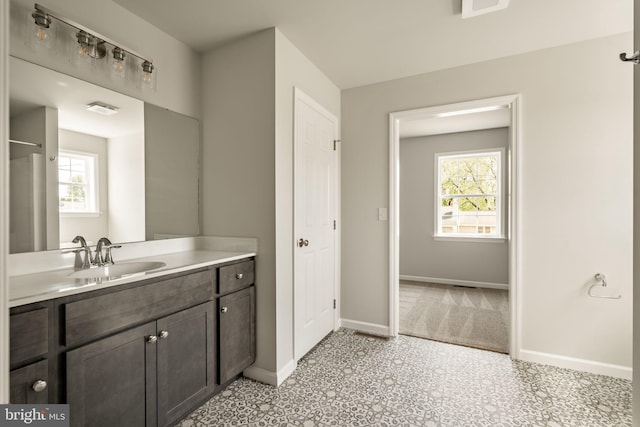 bathroom with baseboards, tile patterned floors, vanity, and plenty of natural light