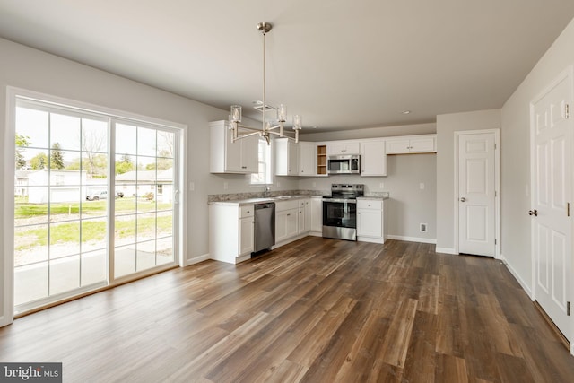kitchen featuring baseboards, white cabinets, appliances with stainless steel finishes, and dark wood-type flooring
