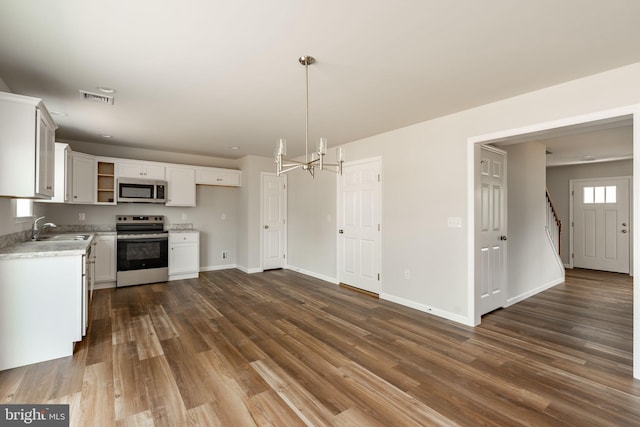 kitchen with open shelves, appliances with stainless steel finishes, a sink, dark wood-style floors, and visible vents