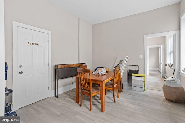 dining area featuring light wood-style flooring and baseboards