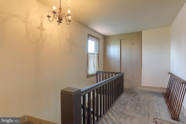 staircase featuring an inviting chandelier and hardwood / wood-style flooring
