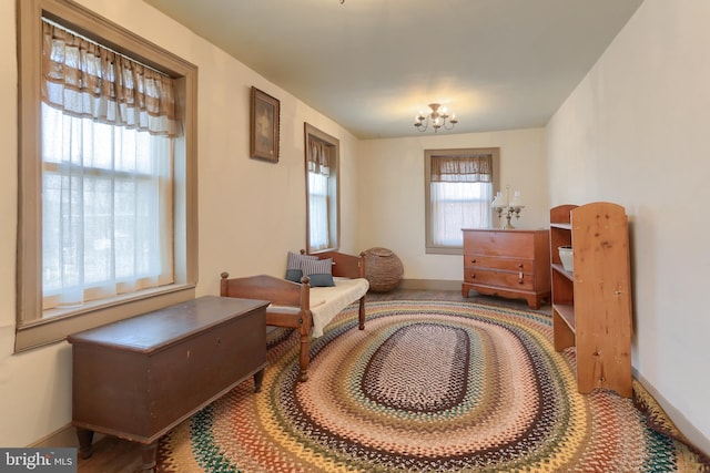 living area with baseboards and a notable chandelier