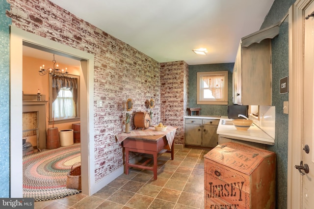bathroom featuring wallpapered walls, a notable chandelier, and a sink