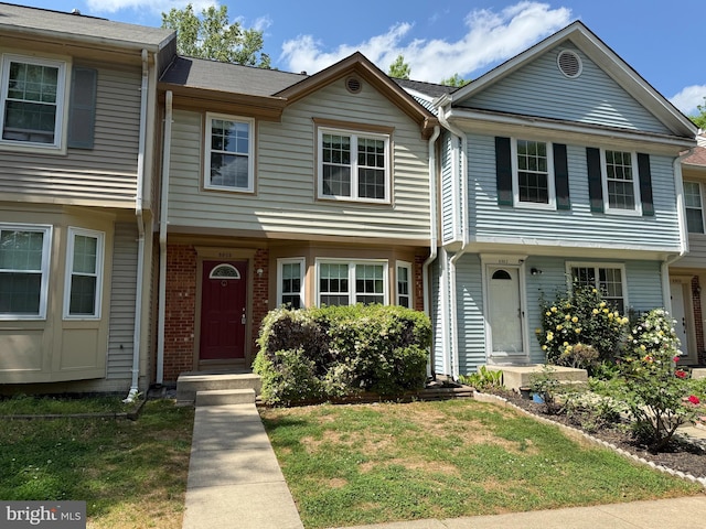 multi unit property with brick siding and a front lawn