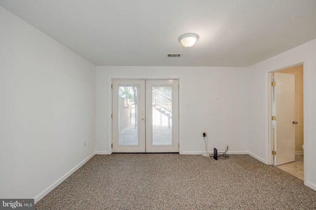 empty room with baseboards, visible vents, french doors, and light colored carpet