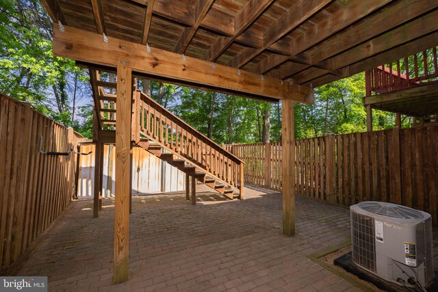 view of patio with stairs, central AC unit, fence, and a deck