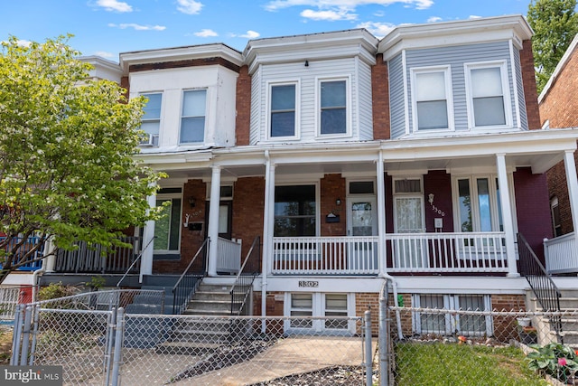 3302 W Belvedere Ave, Baltimore, MD 21215 - multi unit property featuring brick siding, a gate, a fenced front yard, and covered porch