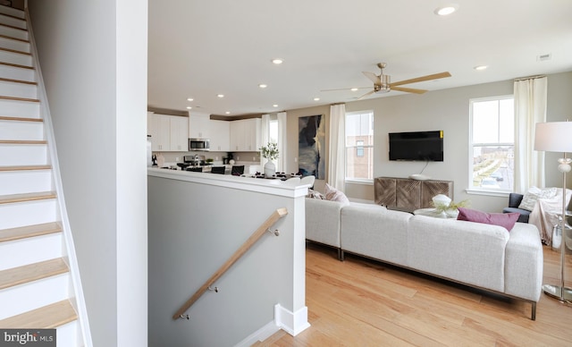 living room with visible vents, a ceiling fan, light wood-style flooring, and recessed lighting