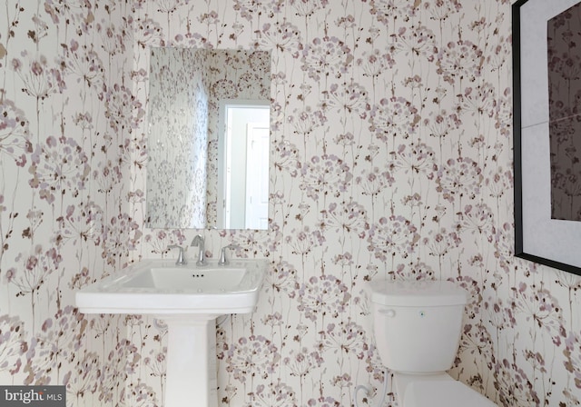 bathroom featuring wallpapered walls and toilet